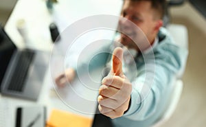 A young designer holds a pen from a tablet in his