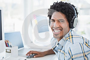 Young designer listening to music as he works