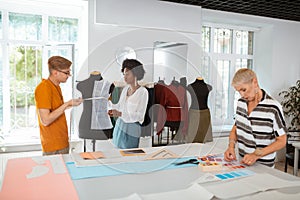 Young designers taking measurements on the tailor dummy