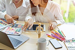 Young designers teamwork working with color samples for selection on office desk,