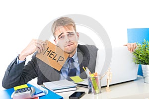 Young desperate businessman holding help sign looking worried suffering work stress at computer desk