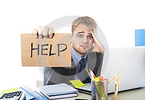 Young desperate businessman holding help sign looking worried suffering work stress at computer desk