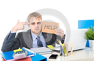 Young desperate businessman holding help sign looking worried suffering work stress at computer desk