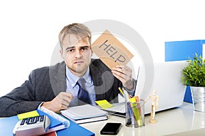 Young desperate businessman holding help sign looking worried suffering work stress at computer desk