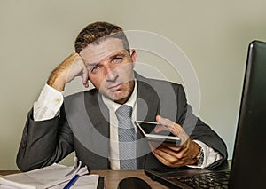 Young desperate and depressed business man suffering problem and depression at office desk working with laptop computer feeling