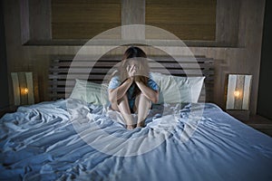 Young desperate and depressed woman crying in bed at night having depression problem and anxiety crisis feeling sad as girl