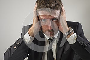 Young desperate and frustrated businessman working stressed and upset sitting at office computer desk serious feeling sad