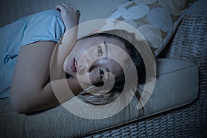 Young desperate sad and depressed Asian Chinese woman sitting at home sofa couch suffering depression problem and anxiety crisis