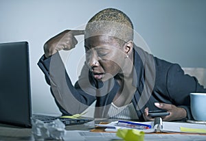 Young desperate and stressed african american business woman working at laptop computer desk at office suffering stress feeling sa