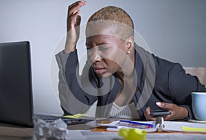 Young desperate and stressed african american business woman working at laptop computer desk at office suffering stress problem us