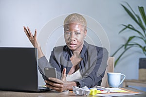 Young desperate and stressed african american business woman working at laptop computer desk at office suffering stress problem us