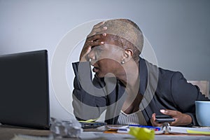 Young desperate and stressed african american business woman working at laptop computer desk at office suffering stress problem us