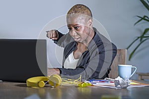 Young desperate and stressed african american business woman working at office desk suffering stress feeling overwhelmed punching