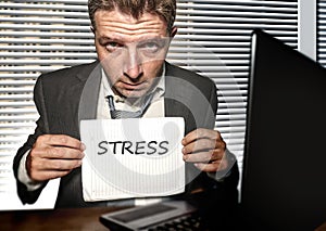 Young desperate and stressed business man working overwhelmed at office computer desk feeling helpless and overworked holding