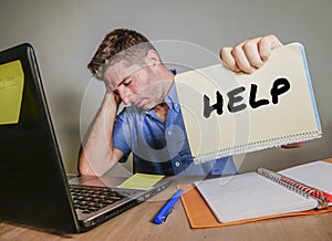 young desperate and stressed businessman feeling overwhelmed working with laptop computer at office desk sad suffering stress ask