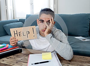 Young desperate student in stress working and studying holding a help sign