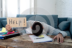 Young desperate student in stress working and studying holding a help sign photo