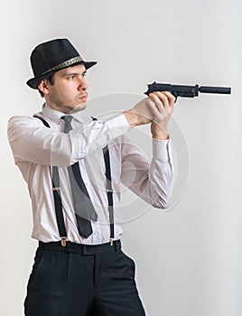 Young detective is aiming with gun with silencer