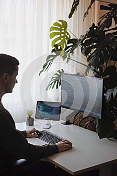 Young developer work with curved screen and tablet.Freelancer is working at home