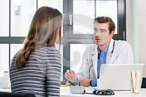 Young devoted doctor listening with attention to his patient