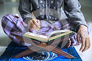 Young devout man reading Quran