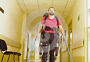 Young disable man in the robotic exoskeleton photo