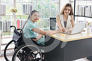 Young disabled Asian businesswoman working together with her colleague in office