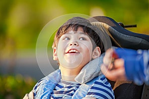 Young disabled boy in wheelchair looking up into sky