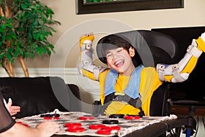 Young disabled boy in wheelchair playing checkers