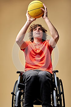young disabled caucasian man in wheelchair train with basketball ball