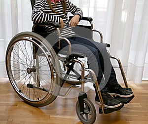 Young disabled child in a wheelchair in her bedroom