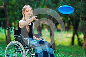 A young disabled girl plays Frisbee with her younger sister. Interaction of a healthy person with a disabled person