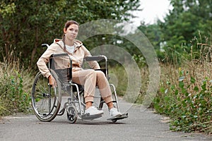 A young disabled girl sits in a wheelchair on the street. The concept of a wheelchair, disabled person, full life, paralyzed,