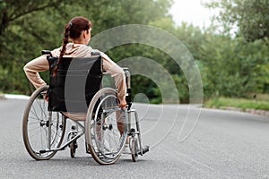 A young disabled girl sits in a wheelchair on the street. The concept of a wheelchair, disabled person, full life, paralyzed,