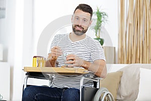 Young disabled injured man having breakfast