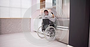 Young Disabled Man Sitting On Wheel Chair Preparing Food