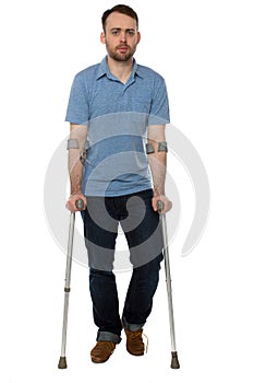Young disabled man walking with forearm crutches photo