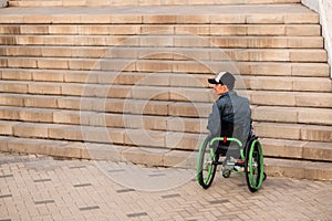 a young disabled person in a wheelchair can not enter the stairs. Accessible environment for the disabled