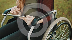 Young disabled woman using tablet outdoors. Close up