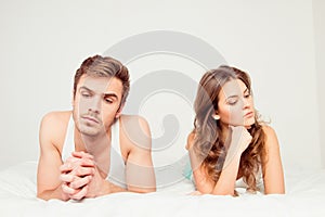 Young disconnected couple lying on the bed