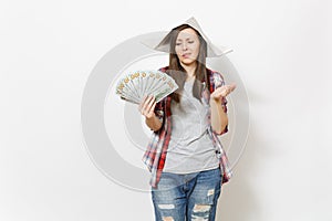 Young dissatisfied beautiful woman in casual clothes, newspaper hat holding bundle of dollars, cash money isolated on