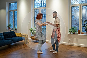 Young diverse couple in love preparing first wedding dance together at home