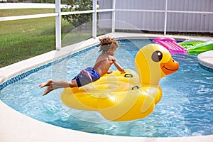 Giovane diversificato poco ragazzo saltando sul il grande gonfiabile piscina giocattolo Giardino dietro la casa nuoto piscina sul Caldo estate 