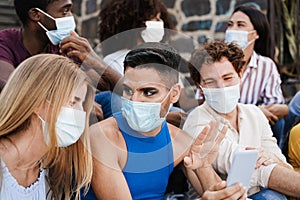 Young diverse people having fun together wearing safety masks outdoor in the city - Focus on drag queen face