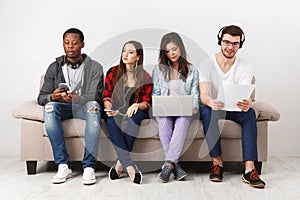 Young diverse people listen to music with gadgets