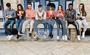 Young diverse people using mobile phones outdoor in the city - Focus on faces