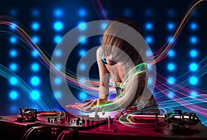 Young Dj girl mixing records with colorful lights