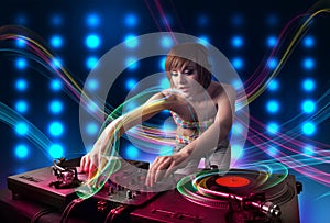 Young Dj girl mixing records with colorful lights