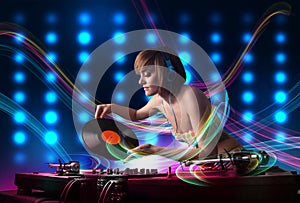 Young Dj girl mixing records with colorful lights