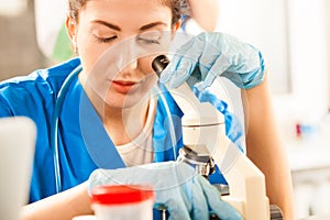 Young doctor assistant working with microscope